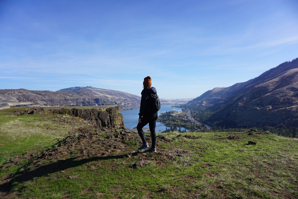 woman in black jacket standing on green grass field during daytime