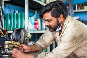 man in white dress shirt holding yellow and black power tool