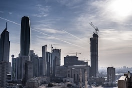 A city skyline with cranes and construction sites representing development finance.