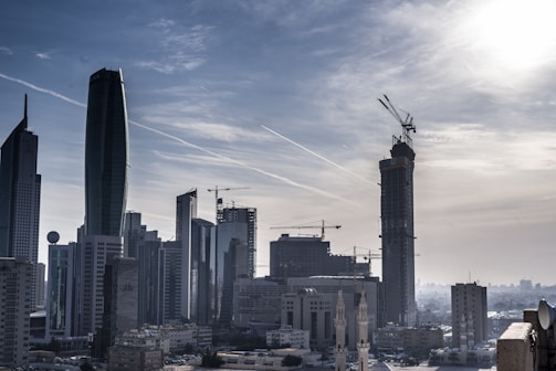 Modern city skyline with construction cranes and infrastructure development.