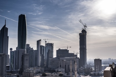 A city skyline with cranes and buildings symbolizing infrastructure growth and development.