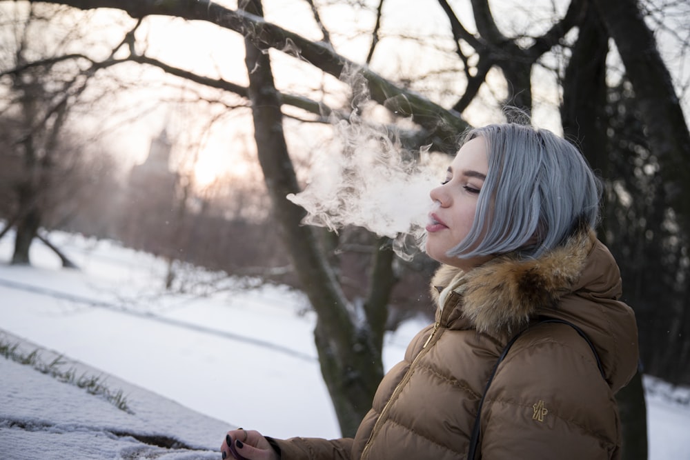 woman in brown winter coat standing on snow covered ground during daytime