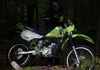 man riding white and green motocross dirt bike
