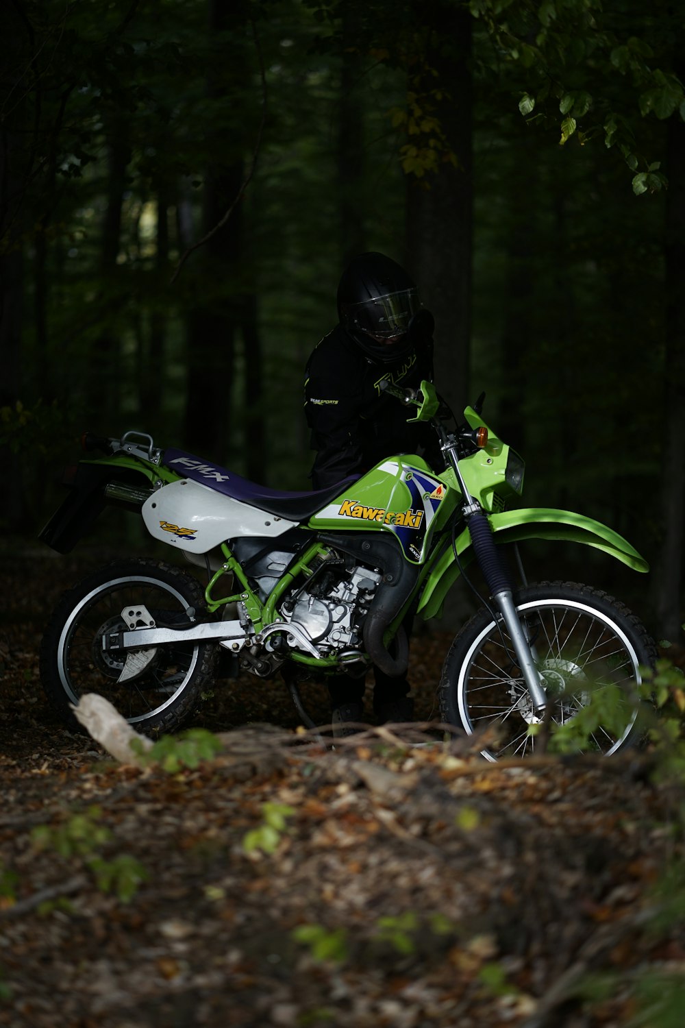 homem que monta moto de terra branca e verde motocross