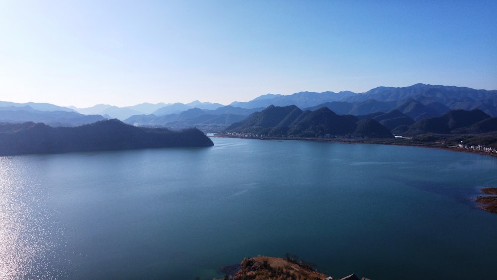 body of water near mountain during daytime