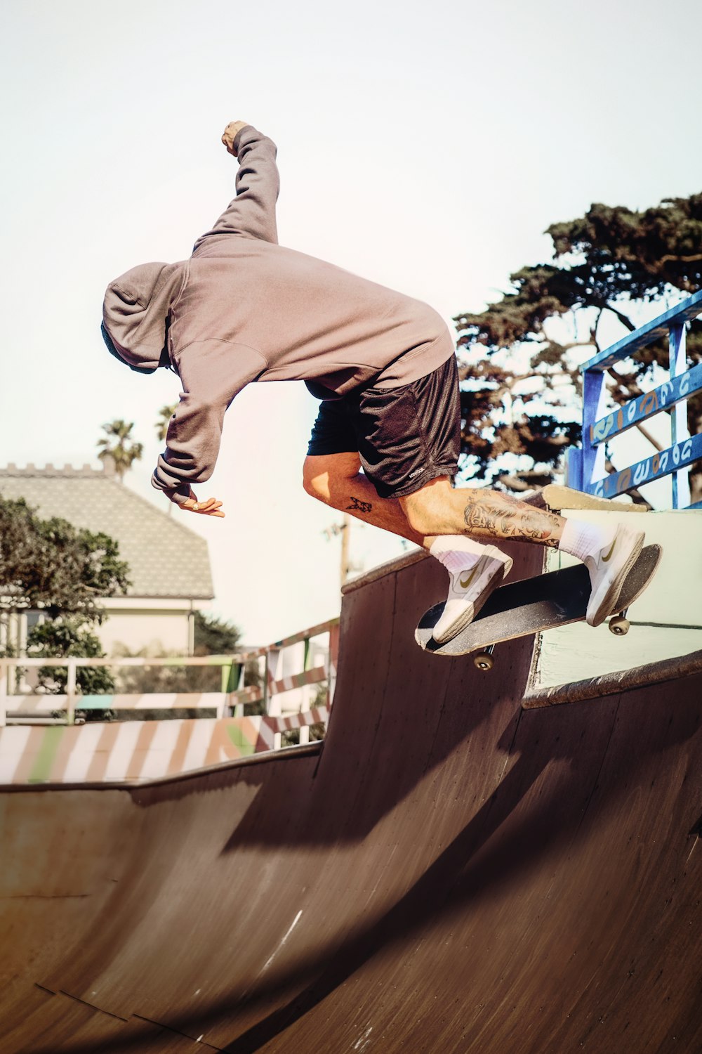 man in gray hoodie and orange shorts jumping on gray concrete bridge during daytime