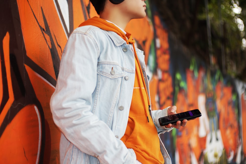 woman in white jacket holding black smartphone