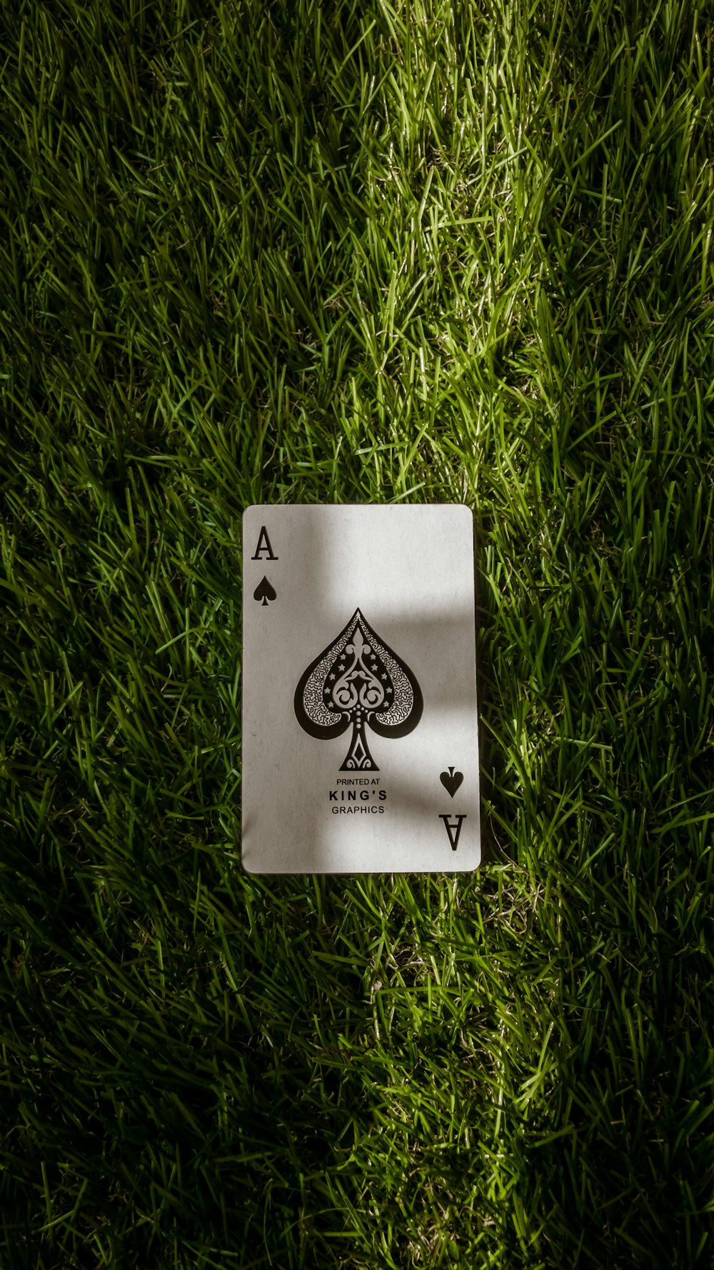ace of spade playing card on green grass