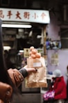 person holding brown egg in white paper