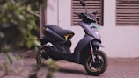 black and yellow motor scooter parked beside white wall