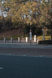 View of a peaceful neighborhood street with nearby shops and bus stops.