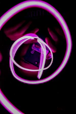 A sleek neon pink cassette floating against a deep black cosmic background with subtle glassmorphism reflections.