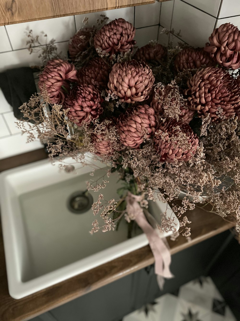 red and brown flowers on white ceramic sink