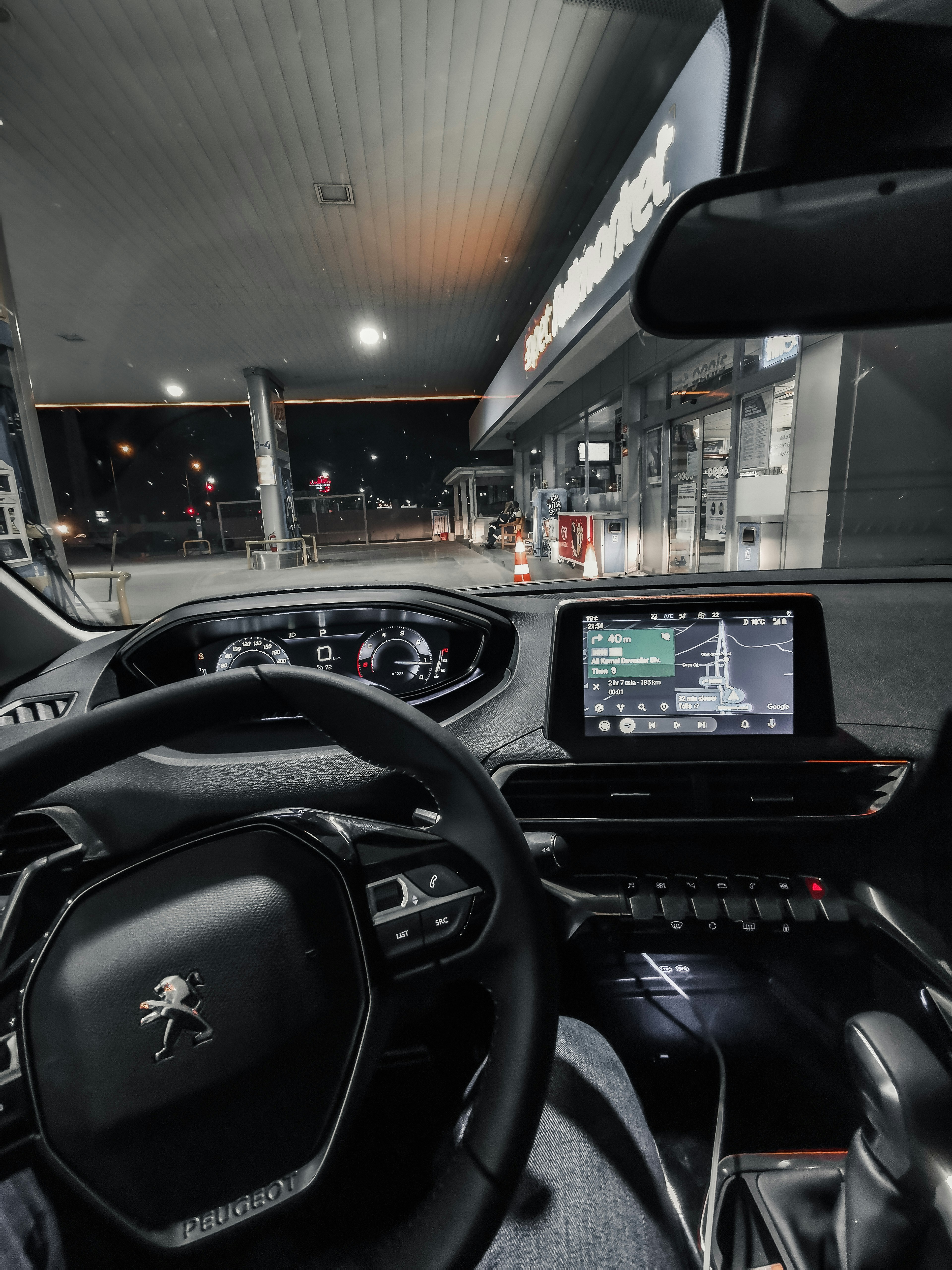 هاتف مثبت في حامل داخل سيارة ليلاً، شاشة GPS مضيئة