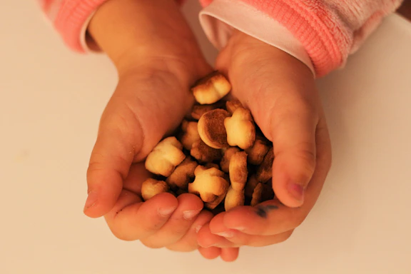 A warm, inviting photo of hands gently holding a small heart-shaped snack.