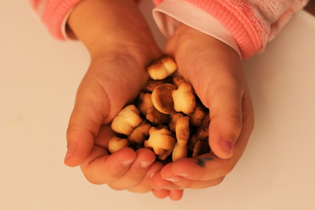 person holding brown nuts on white surface