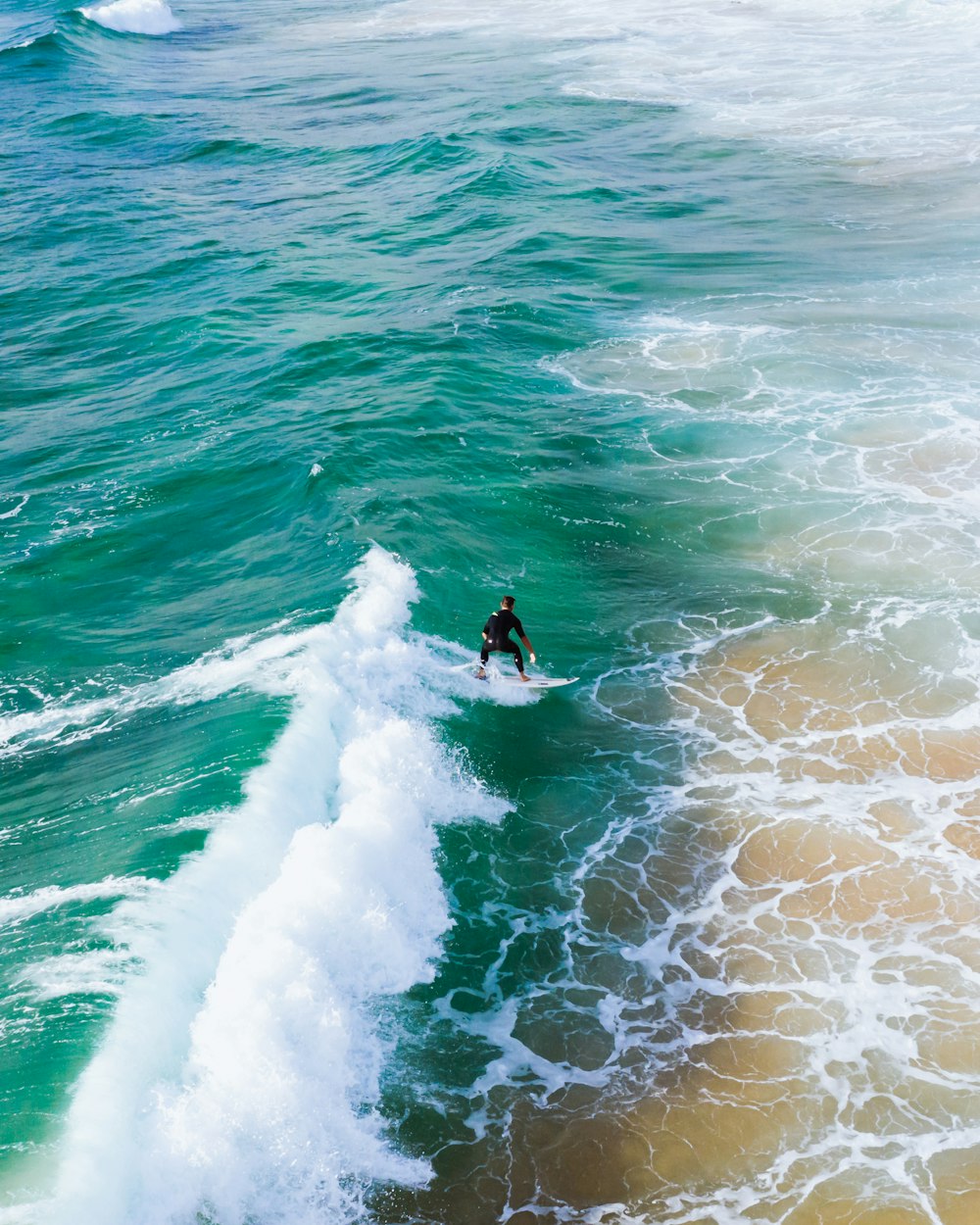 man surfing on sea waves during daytime