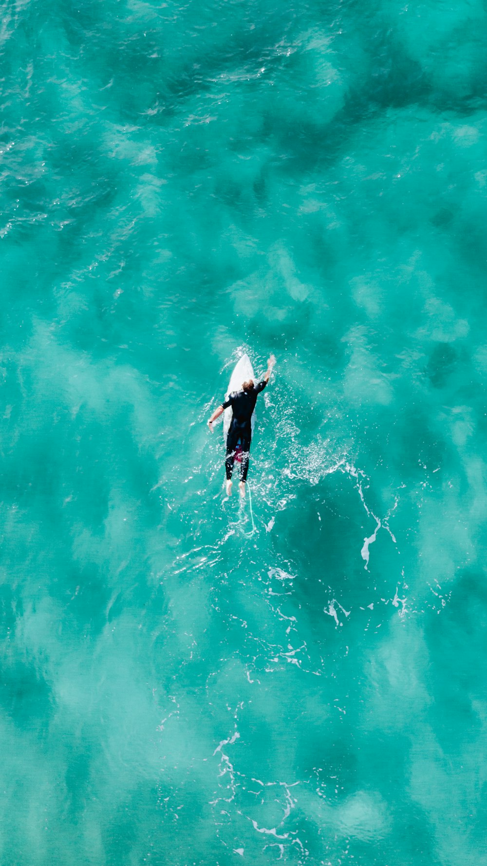 Mann im schwarzen Neoprenanzug Surfen auf dem Wasser