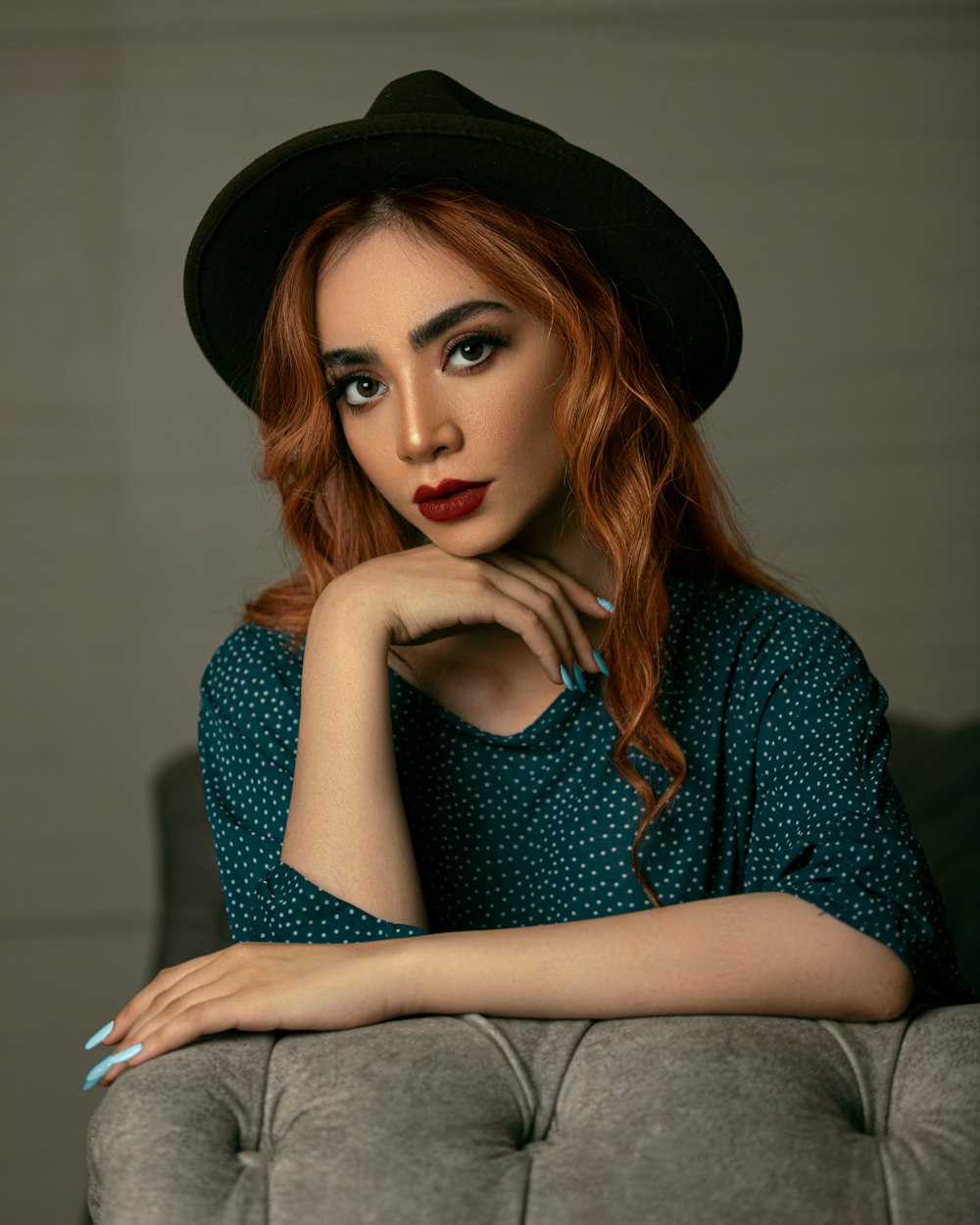 woman in blue and white polka dot dress wearing black hat