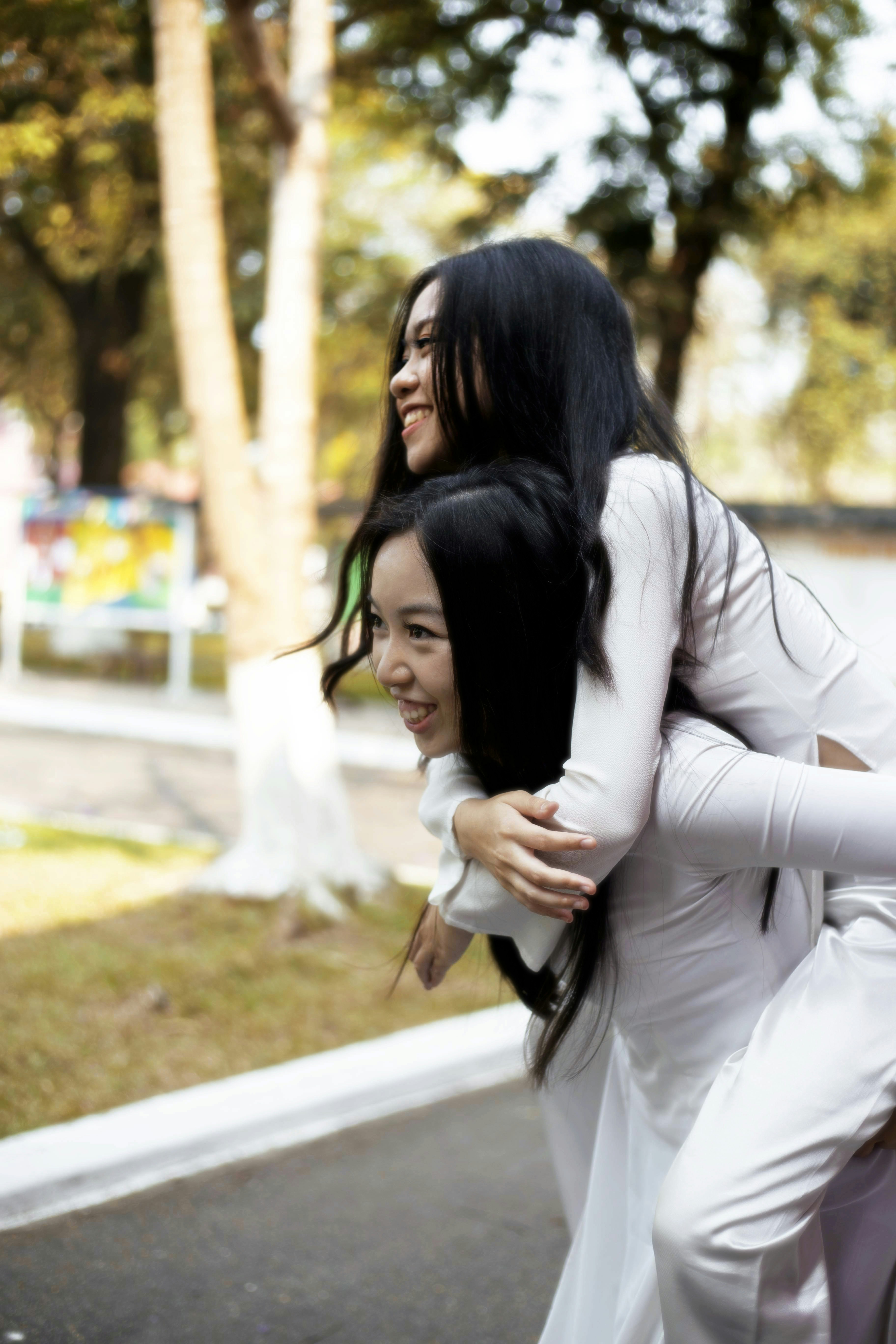 wanita dengan kemeja lengan panjang putih memeluk wanita dengan kemeja lengan panjang putih