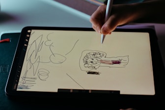 person holding white printer paper with drawing