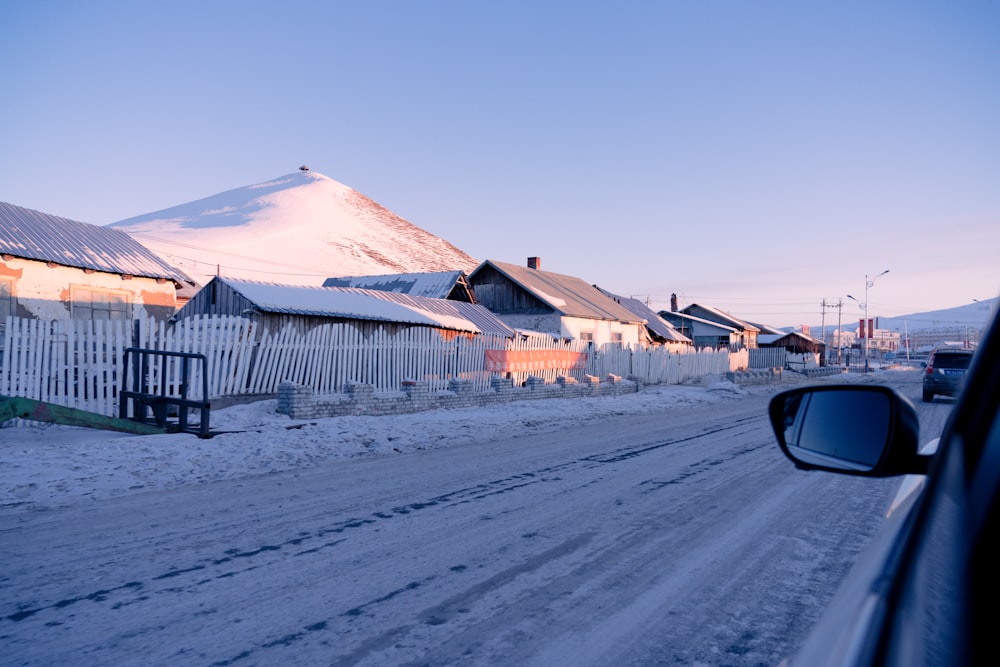 white and brown wooden houses near snow covered field during daytime