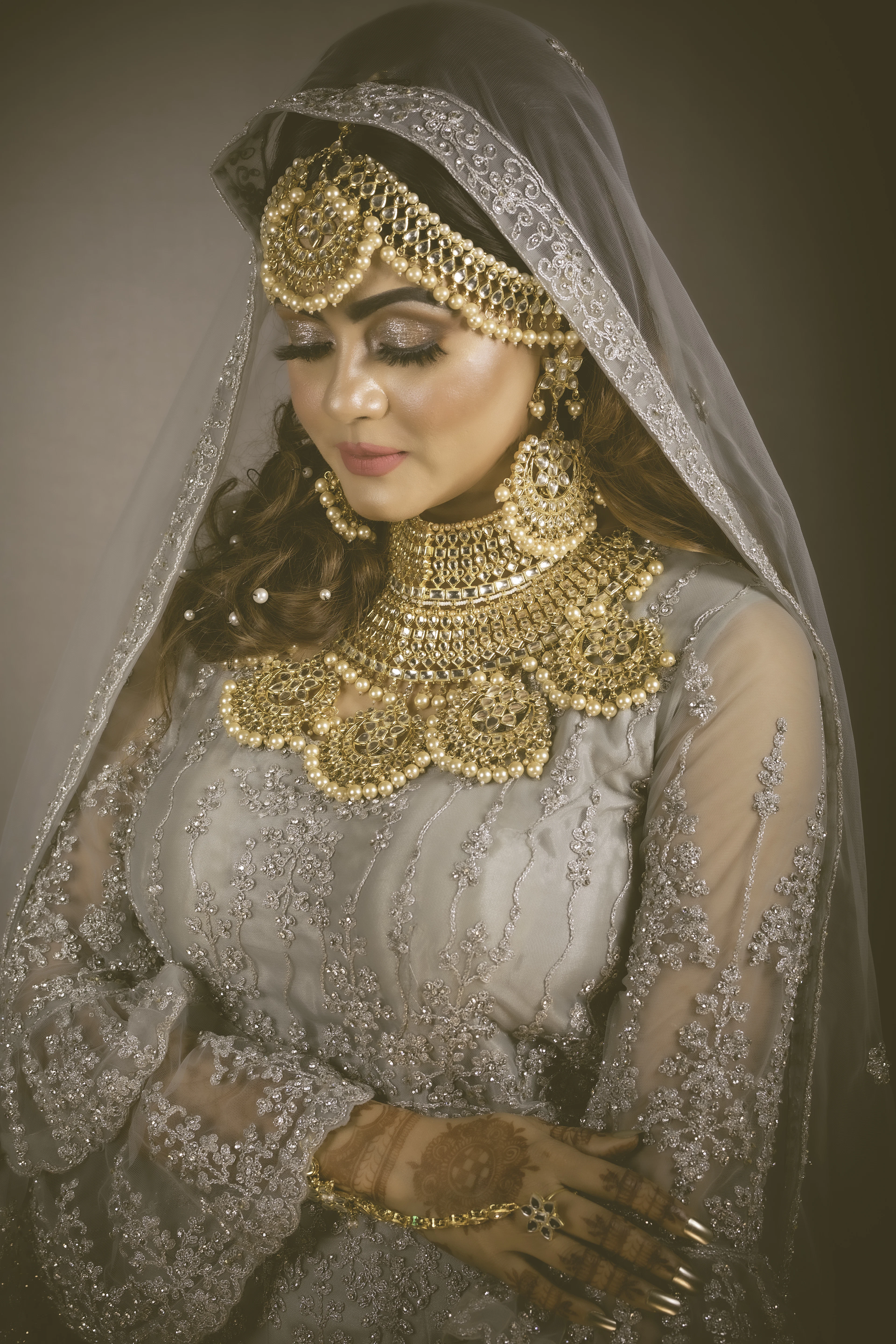 Bride in ivory and silver with a sheer embroidered dupatta