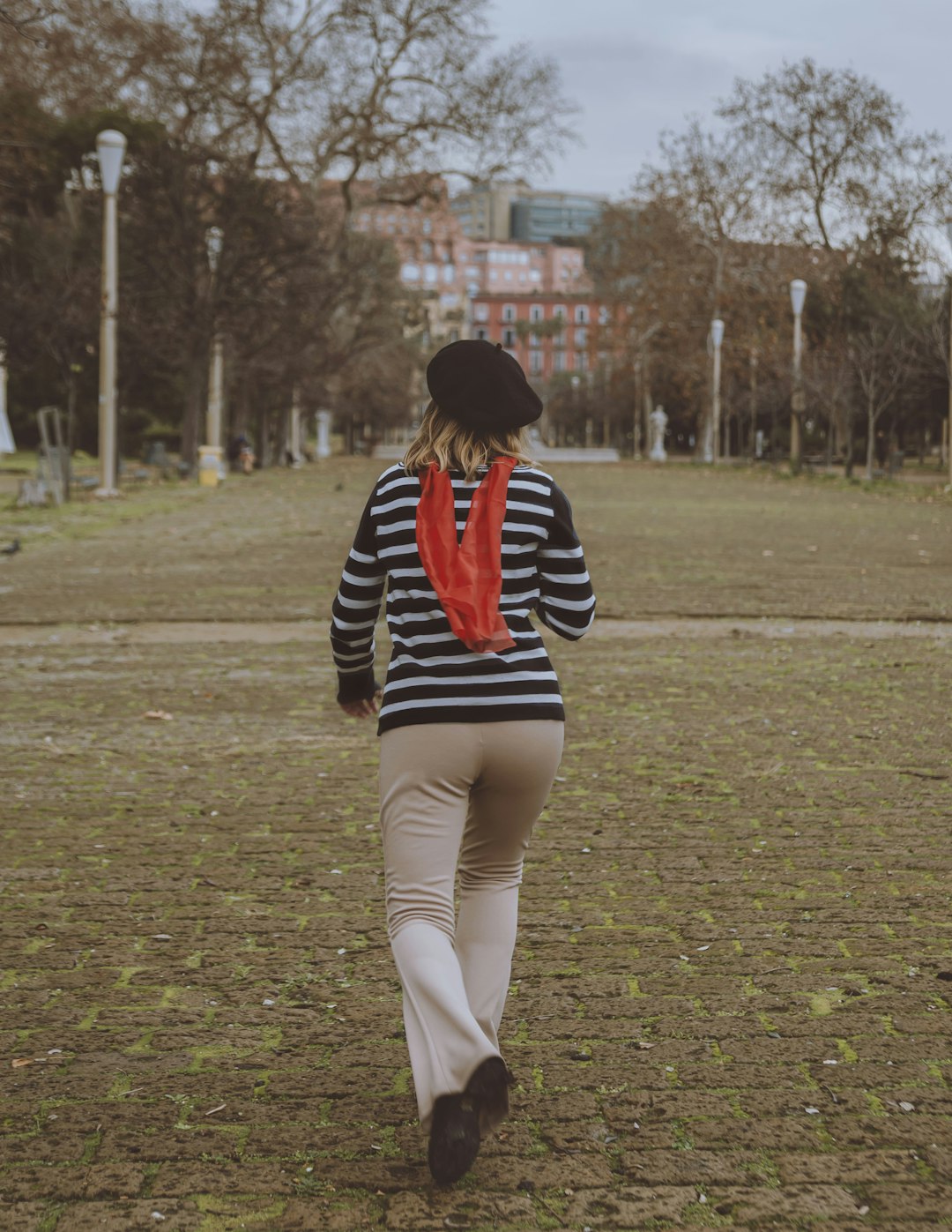 woman in black red and white striped long sleeve shirt and white pants walking on green