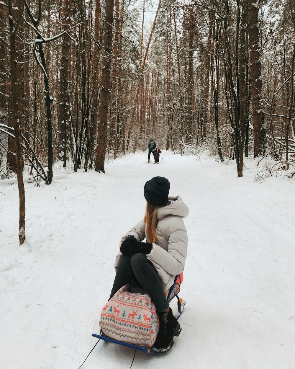 person in gray jacket sitting on snow covered ground during daytime