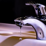 stainless steel faucet on white ceramic sink