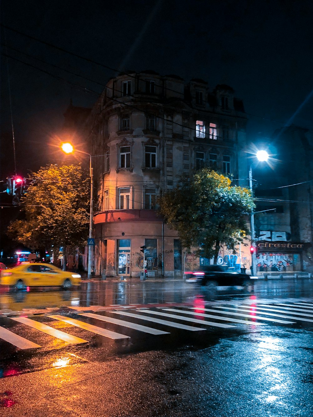 Coches en la carretera cerca de un edificio de hormigón marrón durante la noche