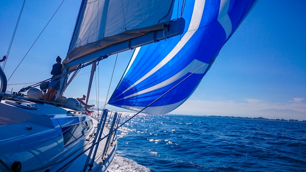 barca a vela bianca e blu in mare durante il giorno