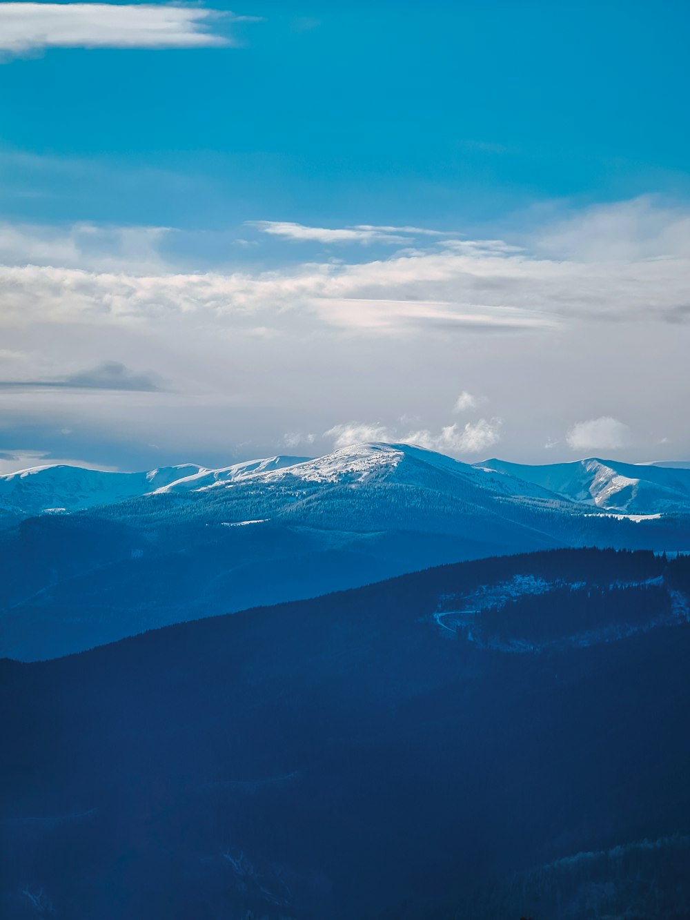 snow covered mountains under cloudy sky during daytime