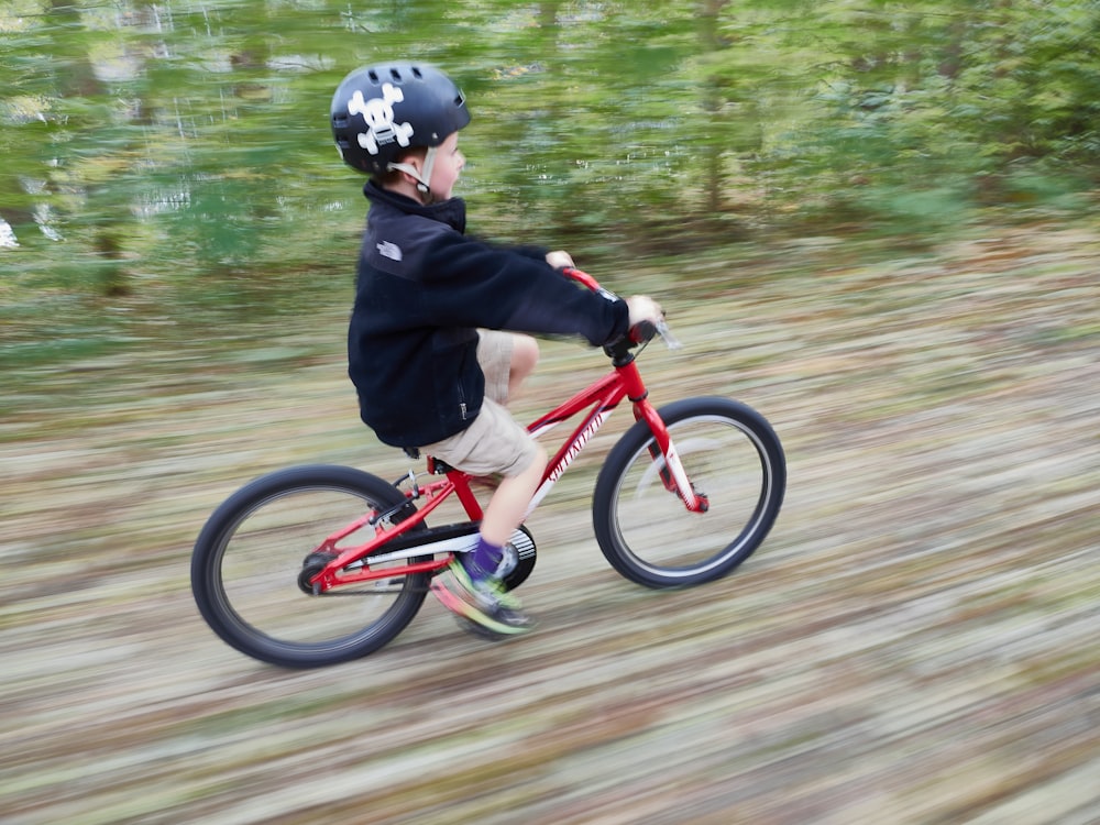 man in black jacket riding red bicycle