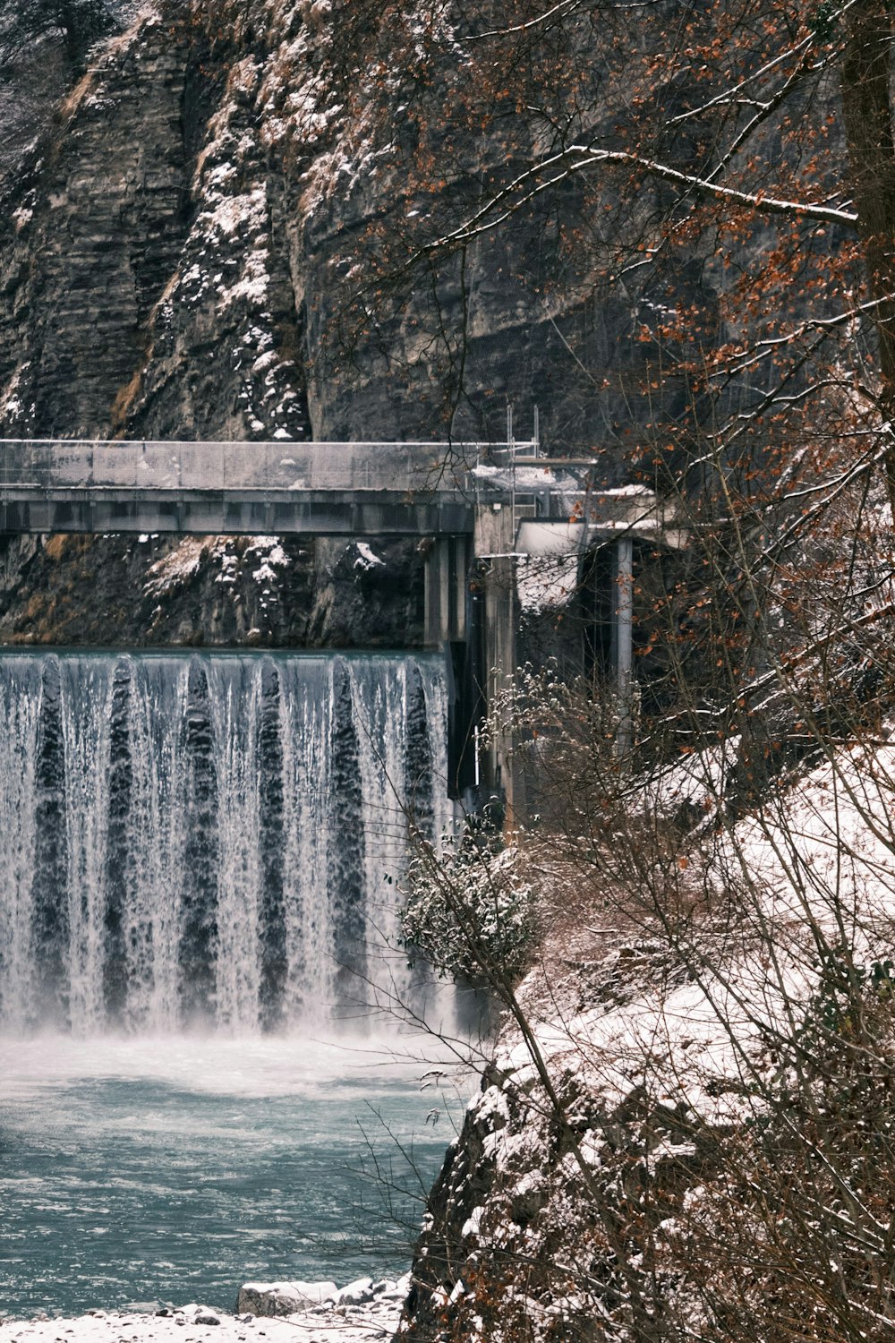 white water falls on gray concrete bridge