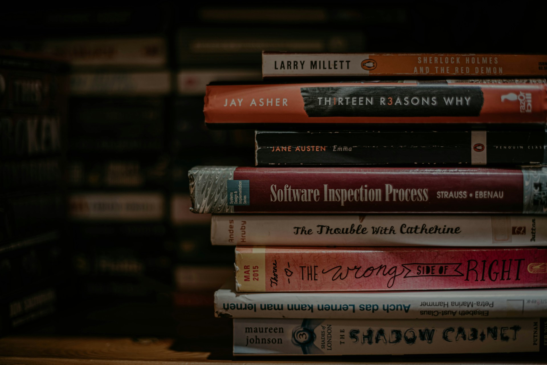 piled books on brown wooden shelf