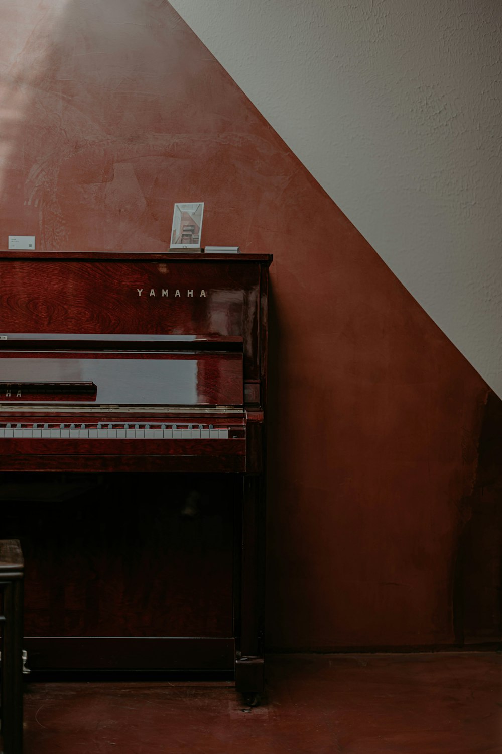 갈색 벽 근처의 갈색 업라이트 피아노