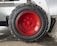 A close-up view of a large, rugged tire with a bright red hubcap mounted on a heavy-duty vehicle. The tire sidewall shows the brand name 'GALAXY' embossed on it. The surrounding area includes parts of the vehicle’s white frame and a concrete floor.