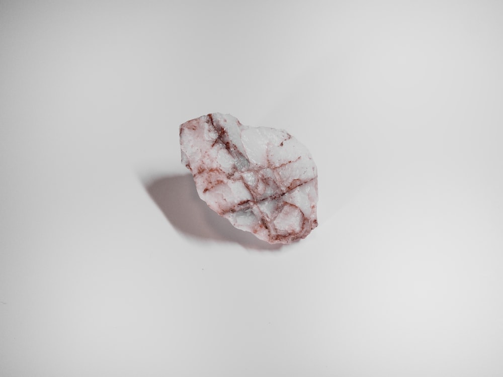 pink crystal on white surface