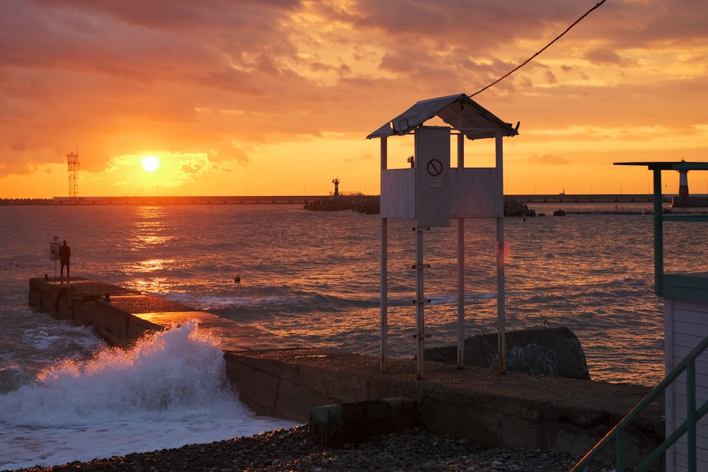 white wooden house on beach during sunset