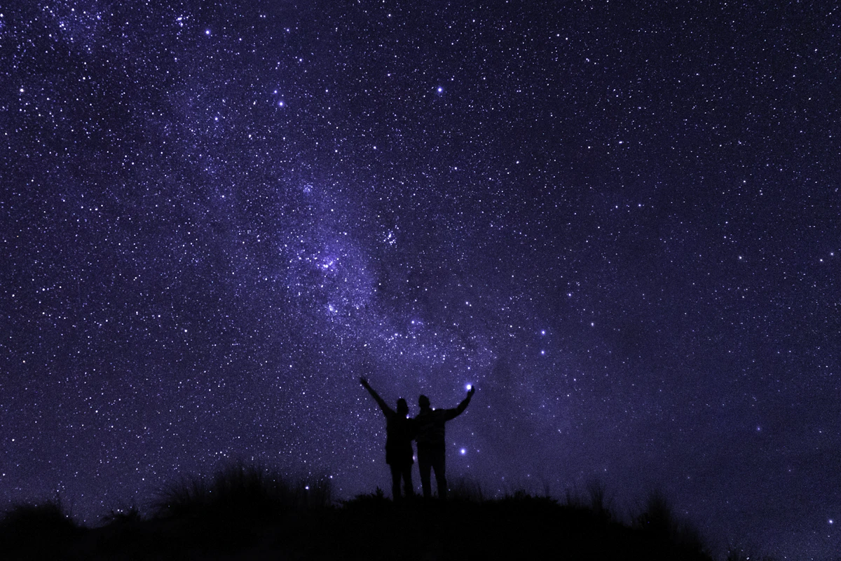 A silhouette gazing up in awe at a vast starry sky