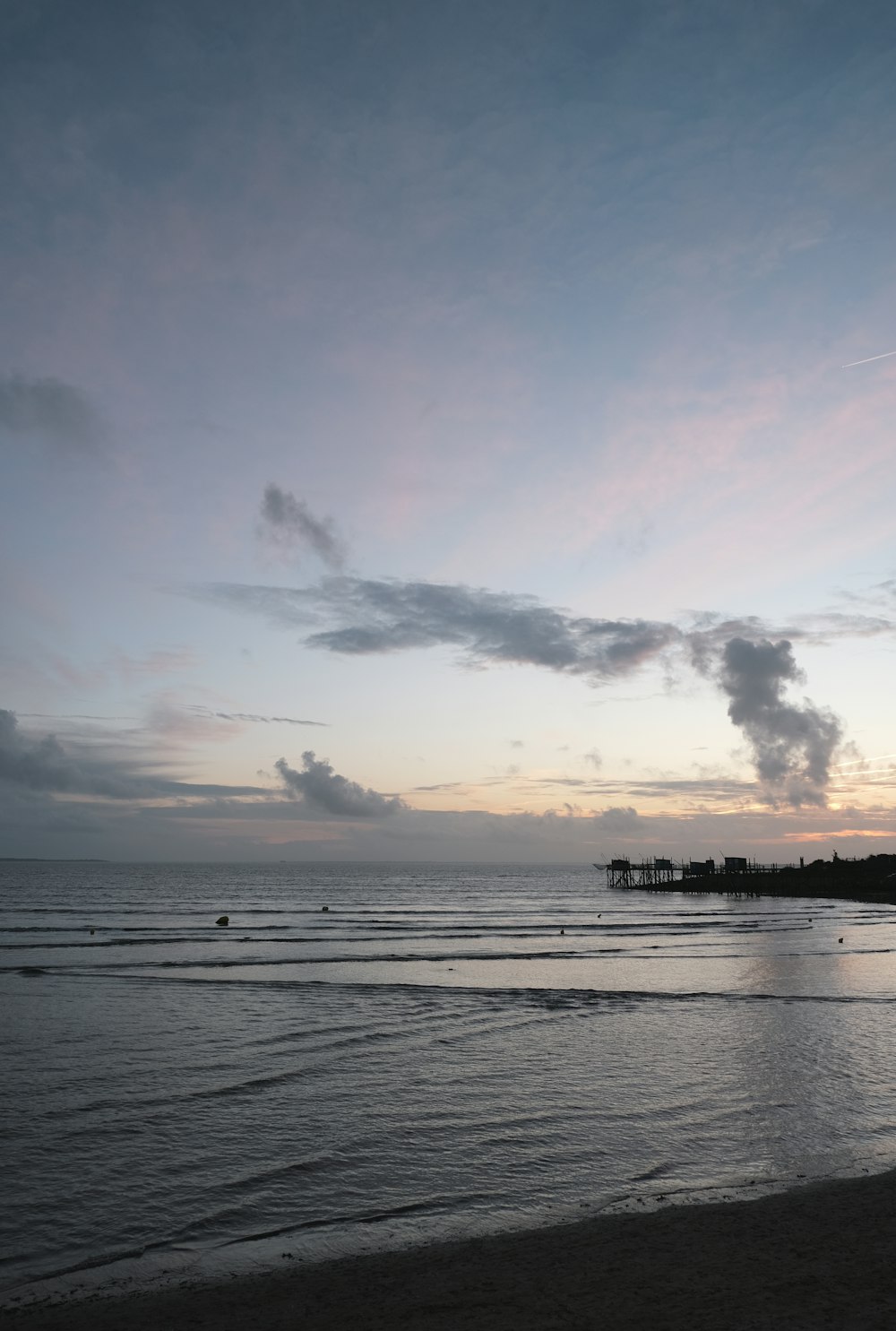 body of water under cloudy sky during daytime