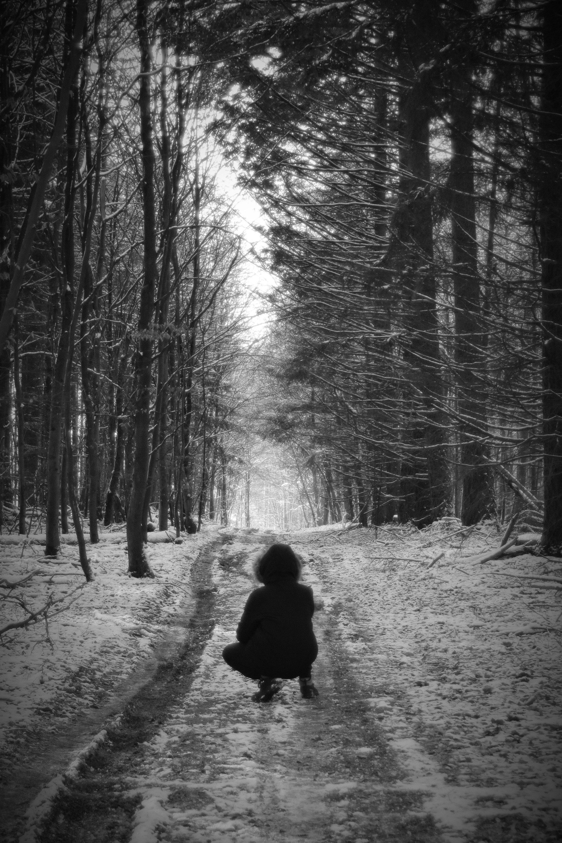 person in black jacket standing on snow covered ground in grayscale photography