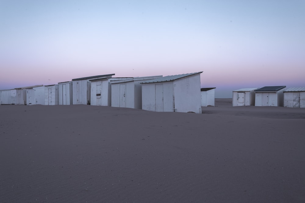 weiße Holzhäuser auf braunem Sand tagsüber