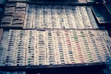 Stack of neatly arranged printed lists on a wooden table.