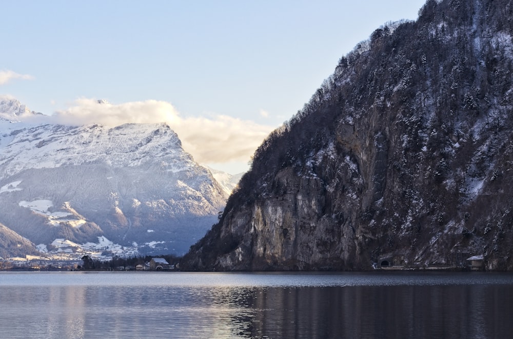 brown and white mountain near body of water during daytime