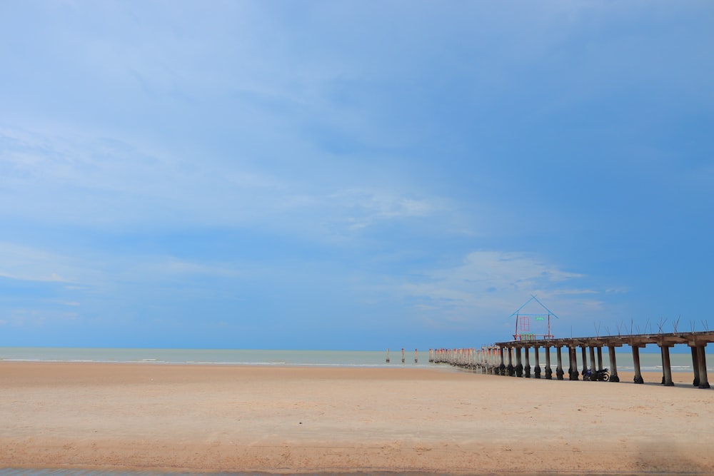 brown wooden fence on beach during daytime