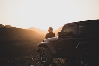 A bold Sierra model parked against a mountain backdrop at sunset.