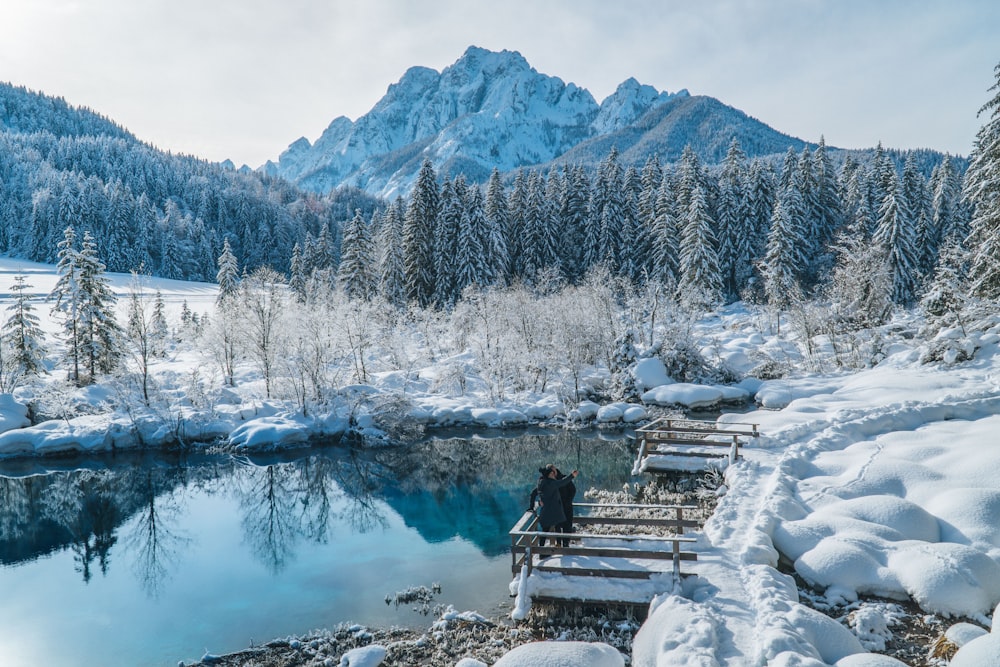 personne assise sur un banc près du lac pendant la journée