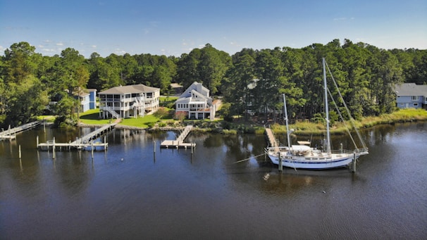A serene waterfront property under Kush Holdings' portfolio, with boats docked nearby.